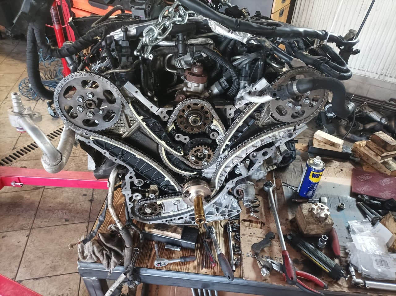 Rozebraný motor s rozvodovými řetězy na montážním stole
